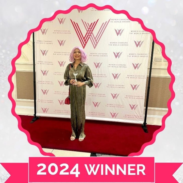 Samita Director Deidaa Eco Gifts standing in front of a branded backdrop with 'Women Changing the World Awards' text, 2024 Winner banner, and website URL.